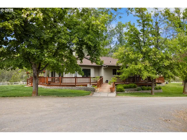 a view of a house with backyard and a tree