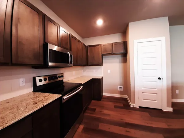 a kitchen with stainless steel appliances granite countertop a refrigerator and a stove top oven