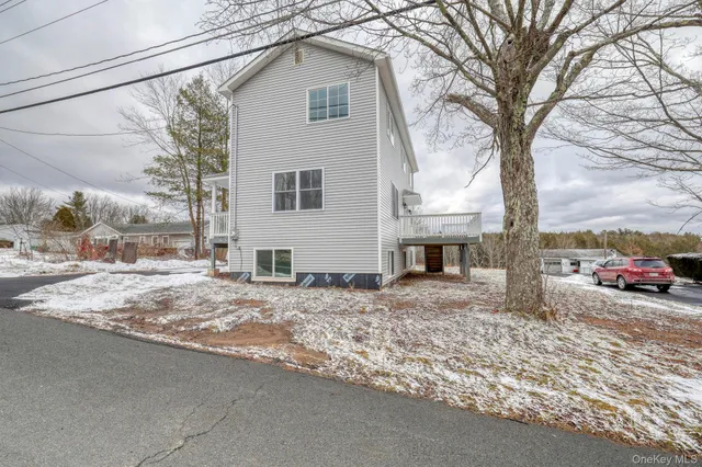 a view of a dry yard covered with snow in front of house