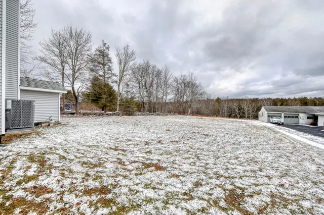 a backyard of house with a bench covered with snow