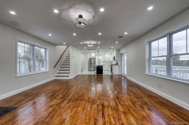 a view of empty room with wooden floor and windows