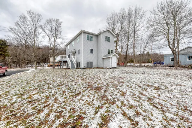 a view of white house with a yard covered in snow