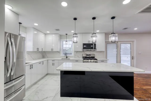 a large kitchen with kitchen island a sink stainless steel appliances and cabinets