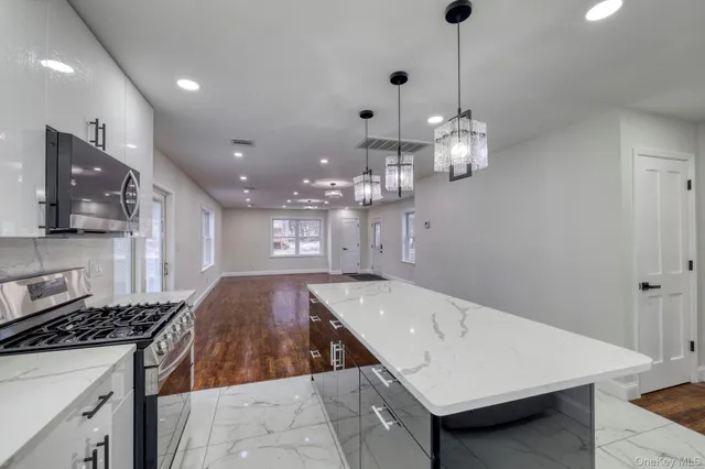 a open kitchen with stainless steel appliances granite countertop a sink a stove and a refrigerator