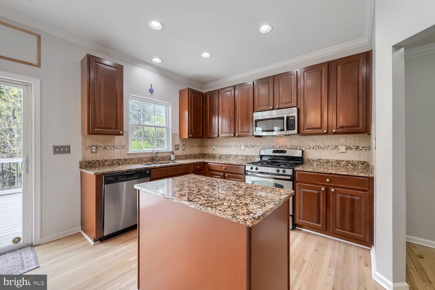 4216 Cross Spring Drive Nottingham, MD 21236 - Photo 14 of 47 a kitchen with stainless steel appliances granite countertop wooden cabinets a stove top oven a sink and dishwasher