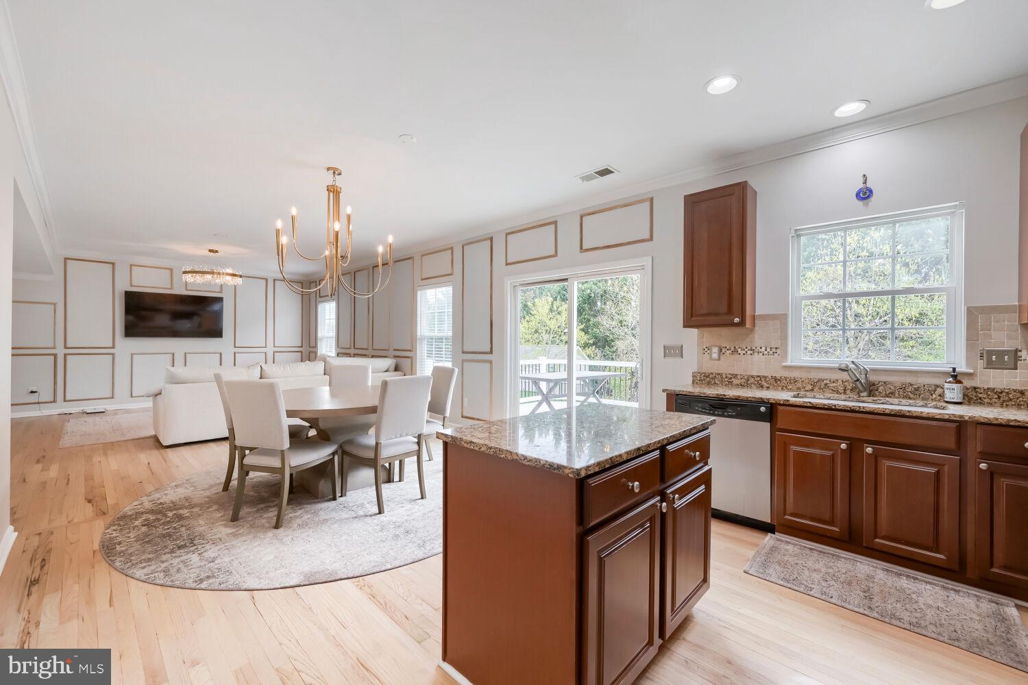 4216 Cross Spring Drive Nottingham, MD 21236 - Photo 15 of 47 a kitchen with stainless steel appliances granite countertop a stove top oven a sink dishwasher a dining table and chairs with wooden floor