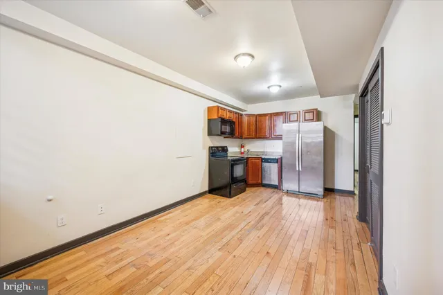 a view of kitchen with stainless steel appliances wooden floor