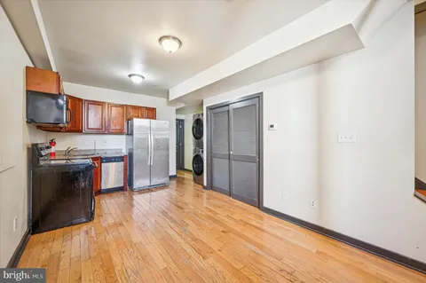 a kitchen with stainless steel appliances a refrigerator and a wooden floor