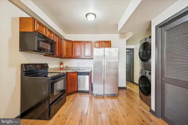 a kitchen with stainless steel appliances granite countertop a refrigerator a stove top oven a sink and dishwasher