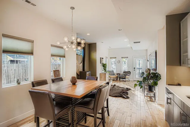 a view of a dining room and livingroom with furniture wooden floor a chandelier