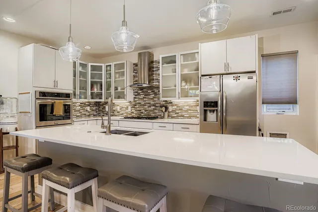 a kitchen with stainless steel appliances a sink a stove a refrigerator and cabinets