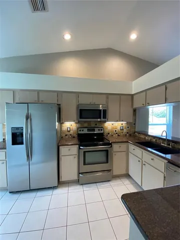 a kitchen with stainless steel appliances granite countertop a sink and a stove