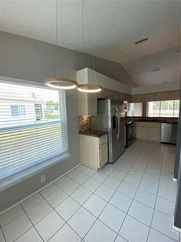 a kitchen with stainless steel appliances kitchen island granite countertop a sink and a stove
