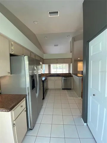 a kitchen with granite countertop a refrigerator and a stove