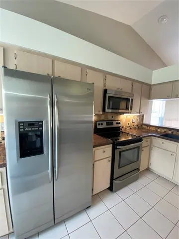 a kitchen with stainless steel appliances granite countertop a refrigerator and a sink