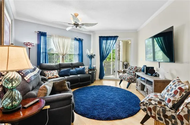 a living room with furniture a large window and a chandelier