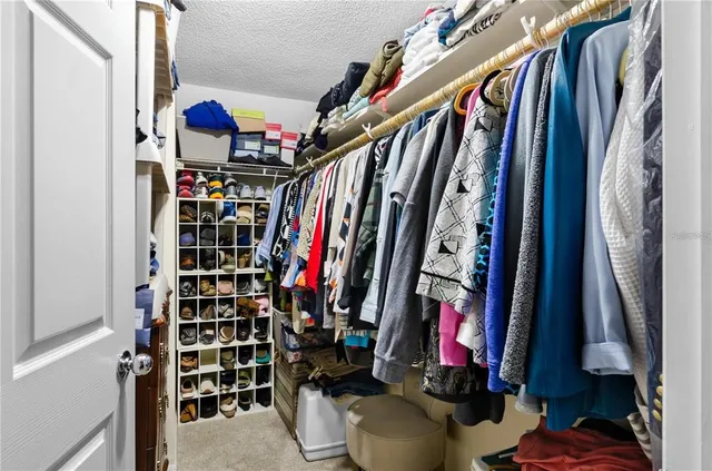 a view of walk in closet with clothes and shoes
