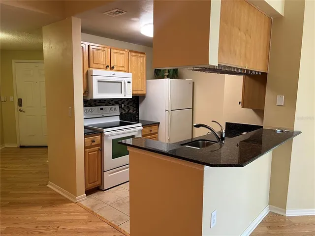 a kitchen with a refrigerator and a stove top oven