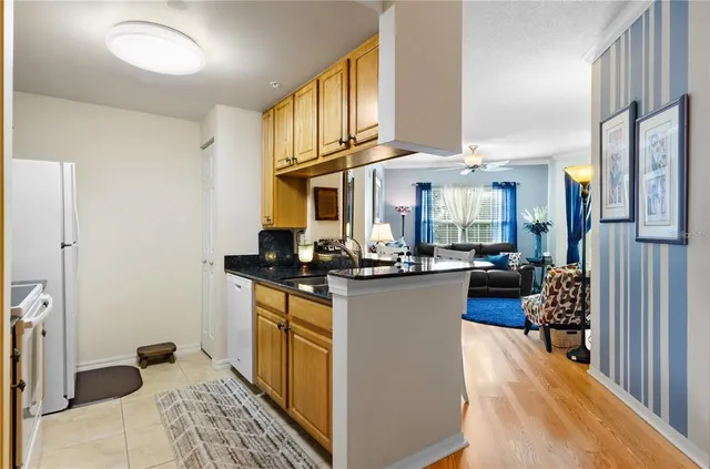 a kitchen with stainless steel appliances kitchen island granite countertop a refrigerator a stove and a sink