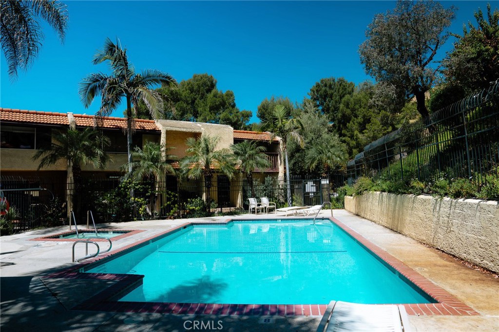 9759 Vía Roma Burbank, CA 91504 - Photo 27 of 29 a view of a swimming pool with lawn chairs under an umbrella