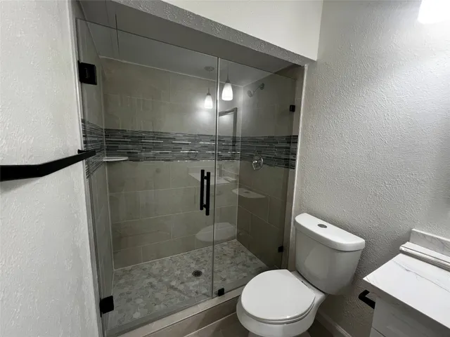a bathroom with a toilet and a shower