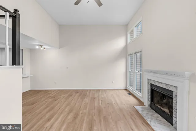 a view of empty room with wooden floor and fireplace