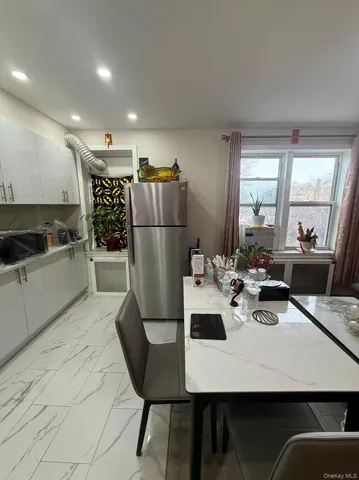 a kitchen with a dining table chairs refrigerator and stove