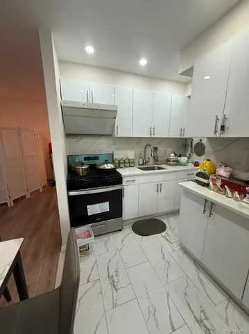 a kitchen with a sink a stove and cabinets