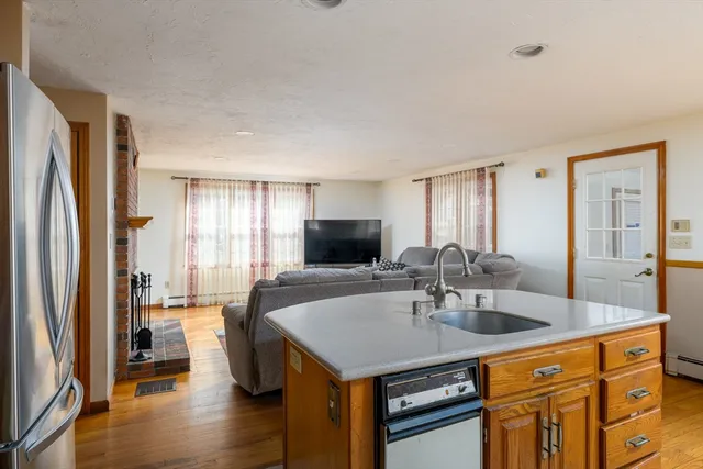 a kitchen with stainless steel appliances granite countertop a sink a microwave refrigerator and a table