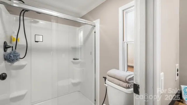 a view of a bedroom with a bed and a window