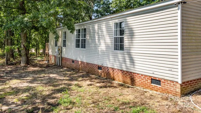 an aerial view of a house with a yard and large trees