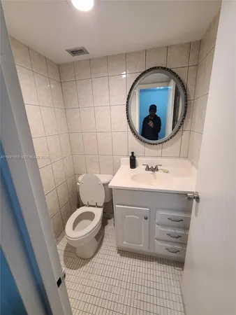 a bathroom with a sink toilet and mirror