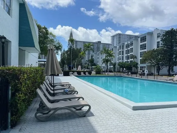 a view of a swimming pool with a patio and a lake view