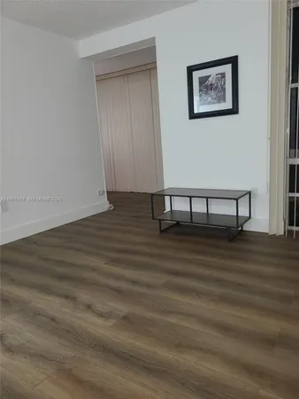 a view of a room with wooden floor and bench