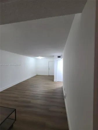 a view of a room with wooden floor and window