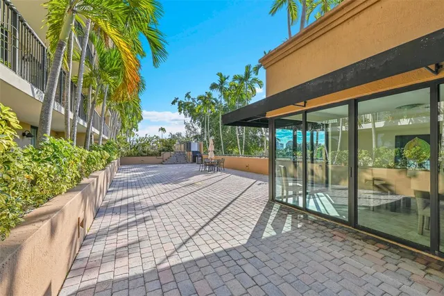 a front view of multi story residential apartment building with yard and sign board