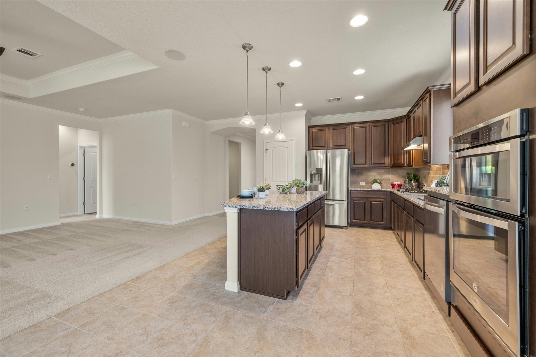 203 Longview Lane Georgetown, TX 78633 - Photo 12 of 37 a large kitchen with stainless steel appliances kitchen island granite countertop a stove a sink dishwasher and a refrigerator with wooden floor