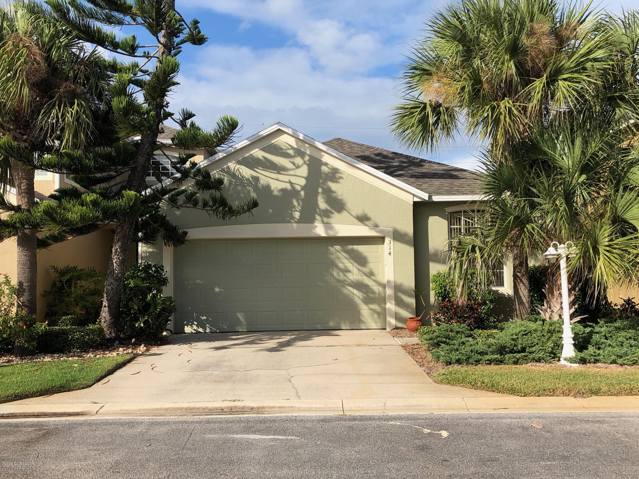 a view of a house with a yard and palm trees