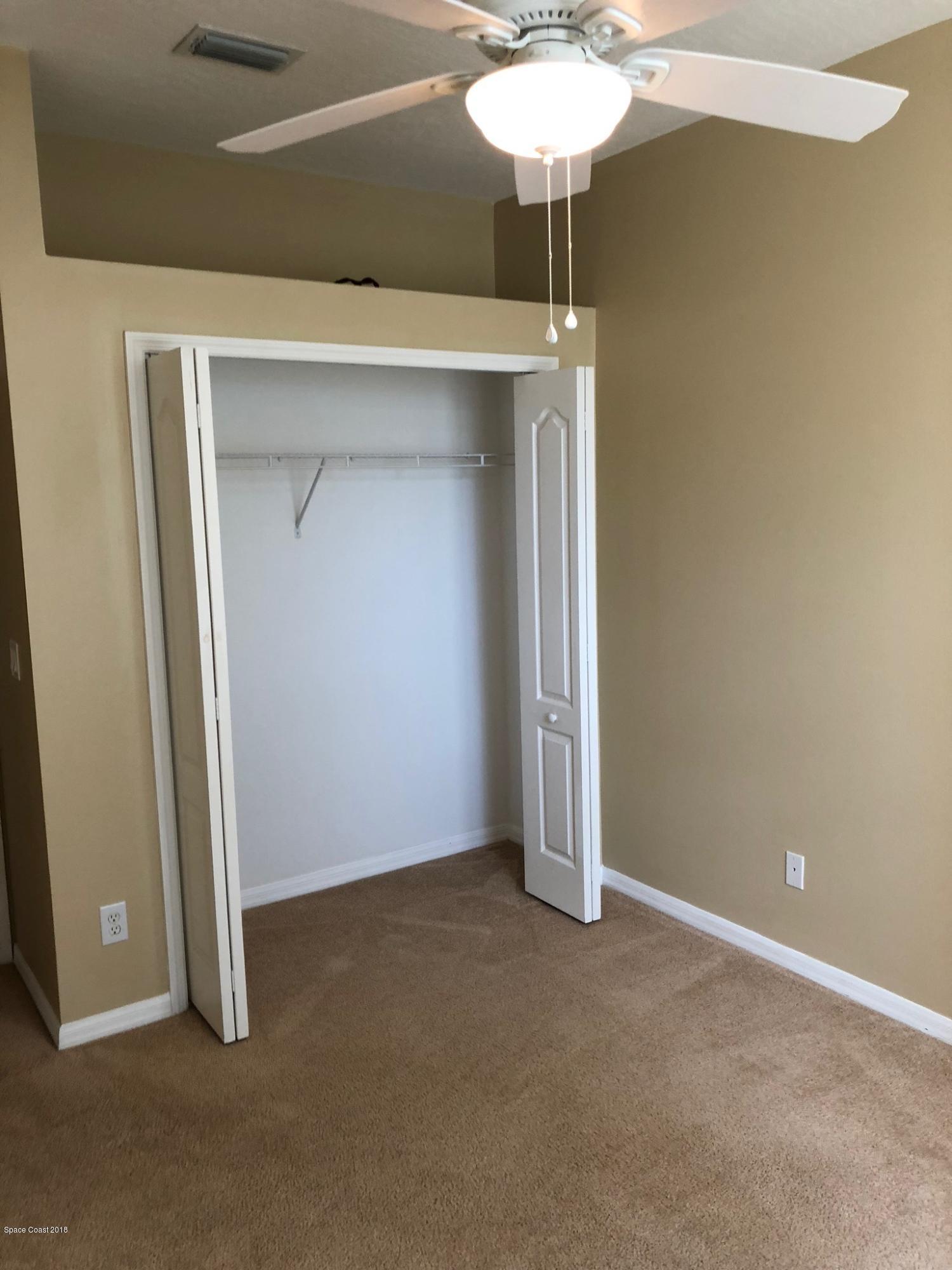 314 Intrepid Way Melbourne, FL 32903 - Photo 29 of 31 an empty room with a chandelier fan and closet