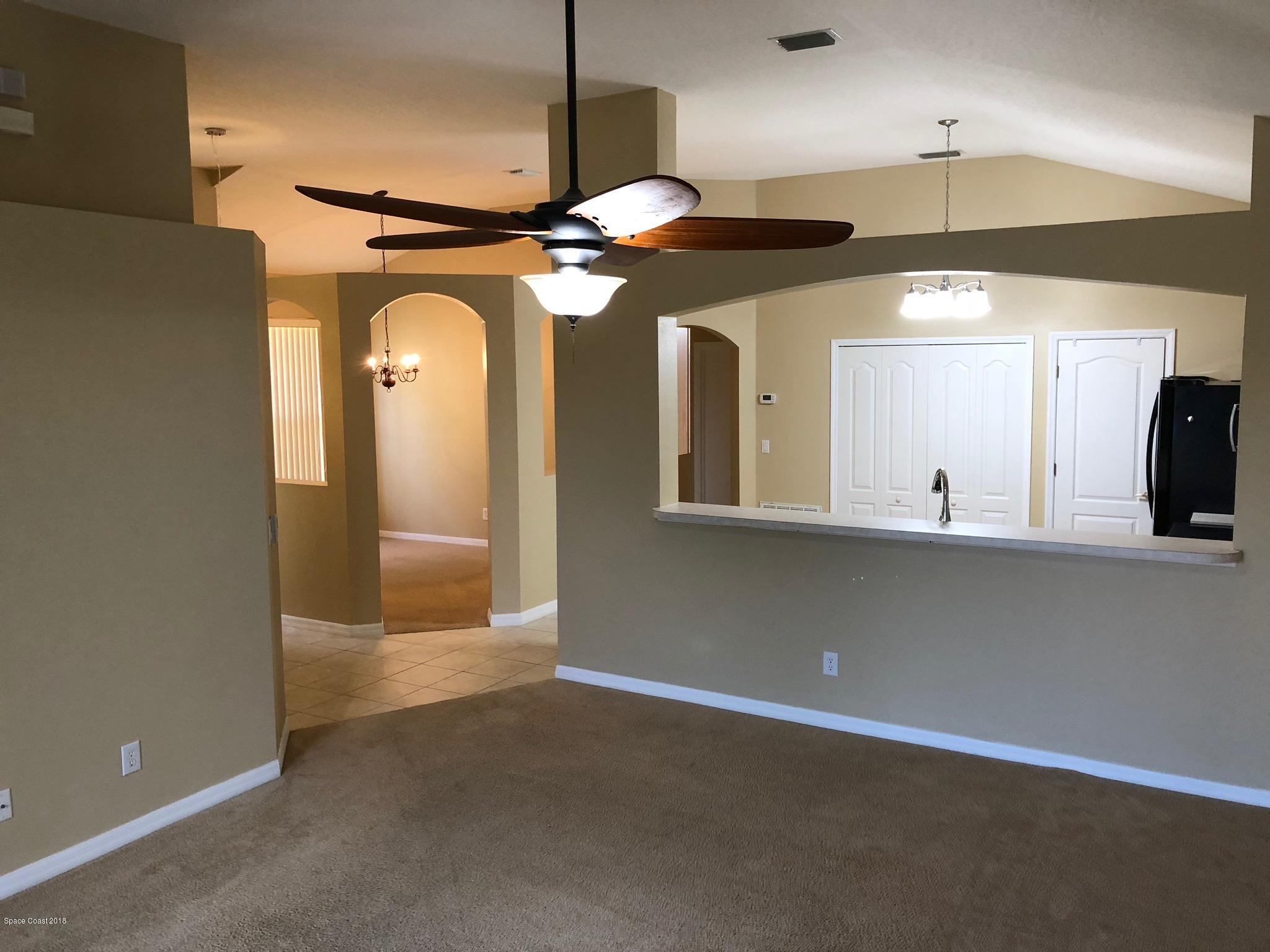 314 Intrepid Way Melbourne, FL 32903 - Photo 5 of 31 a view of a hallway with a chandelier fan and a table