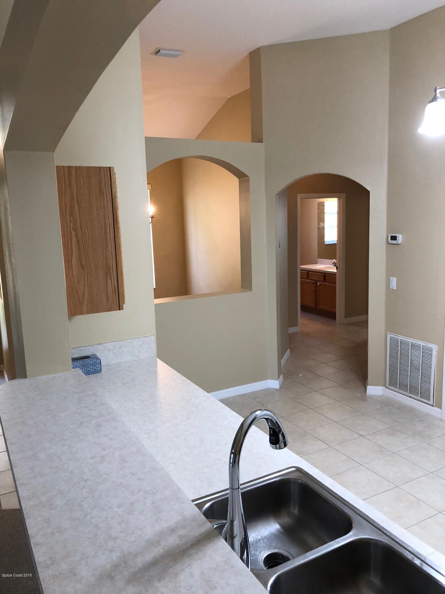 314 Intrepid Way Melbourne, FL 32903 - Photo 8 of 31 a view of a hallway kitchen with a sink and a mirror
