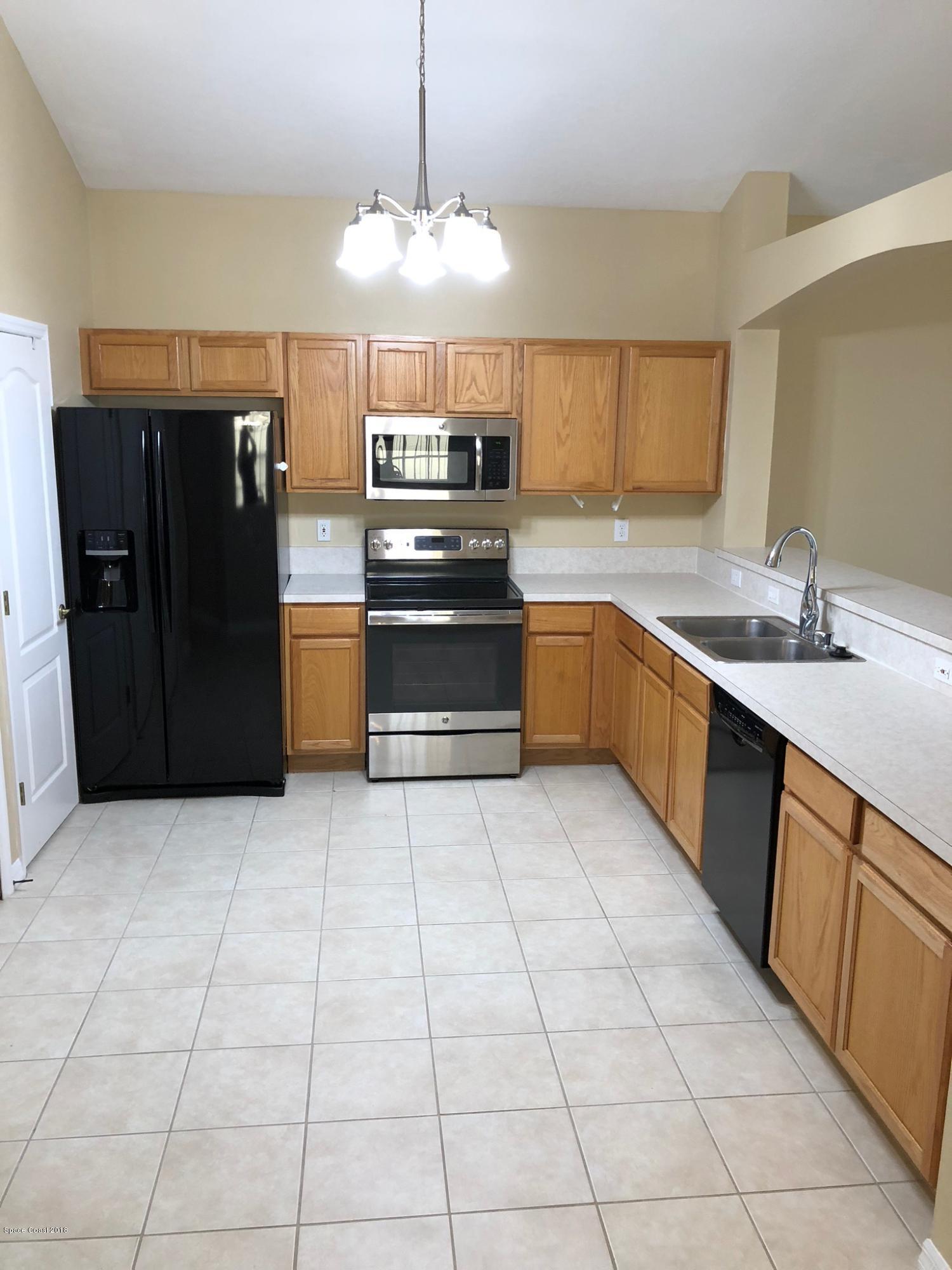 314 Intrepid Way Melbourne, FL 32903 - Photo 9 of 31 a kitchen with stainless steel appliances granite countertop a refrigerator and a sink