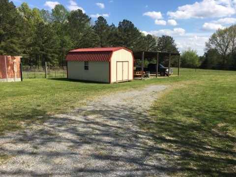 97 North Howard Fitch Road Kelso, TN 37348 - Photo 13 of 30 a backyard of a house with plants and a bench