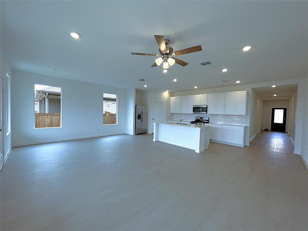 3020 Dutch Road Providence Village, TX 76227 - Photo 3 of 23 a view of an empty room and kitchen with ceiling fan