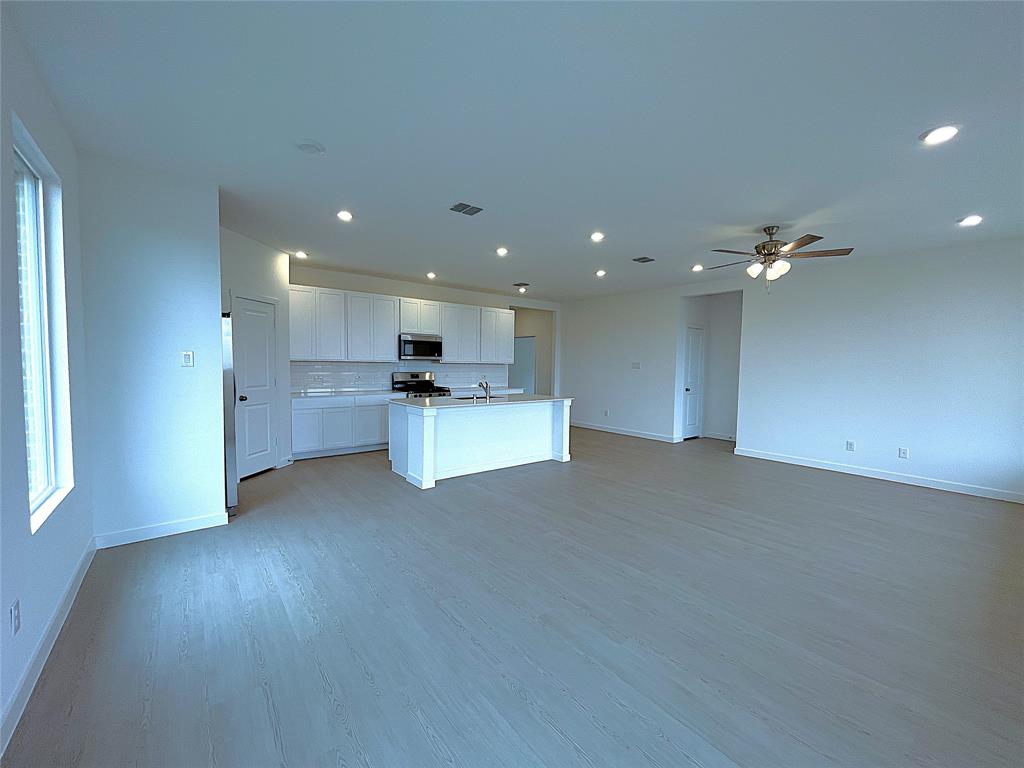 3020 Dutch Road Providence Village, TX 76227 - Photo 4 of 23 a view of a kitchen with a sink and dishwasher a refrigerator with wooden floor