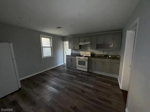 a kitchen with wooden floors and stainless steel appliances