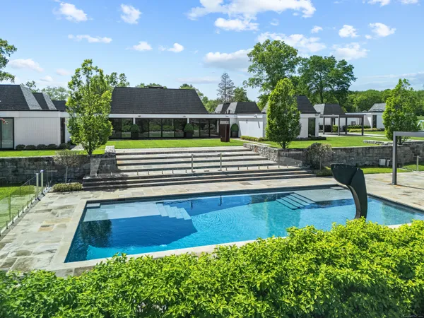 a view of a house with pool and a yard
