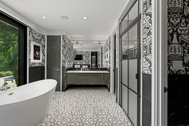 a bathroom with a bathtub a mirror a shower and sink