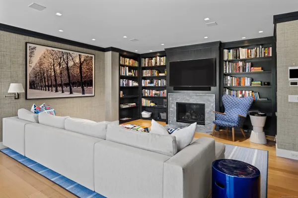 a living room with furniture a flat screen tv and a bookshelf