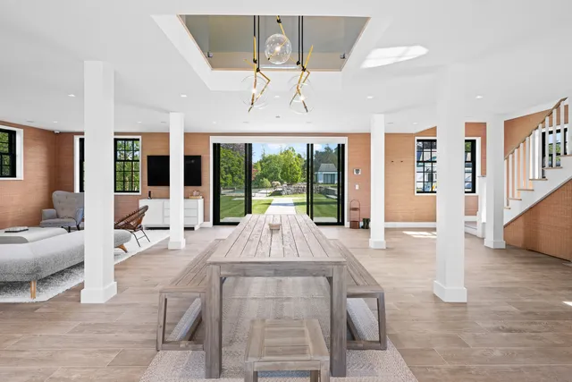 a living room with furniture large window and wooden floor